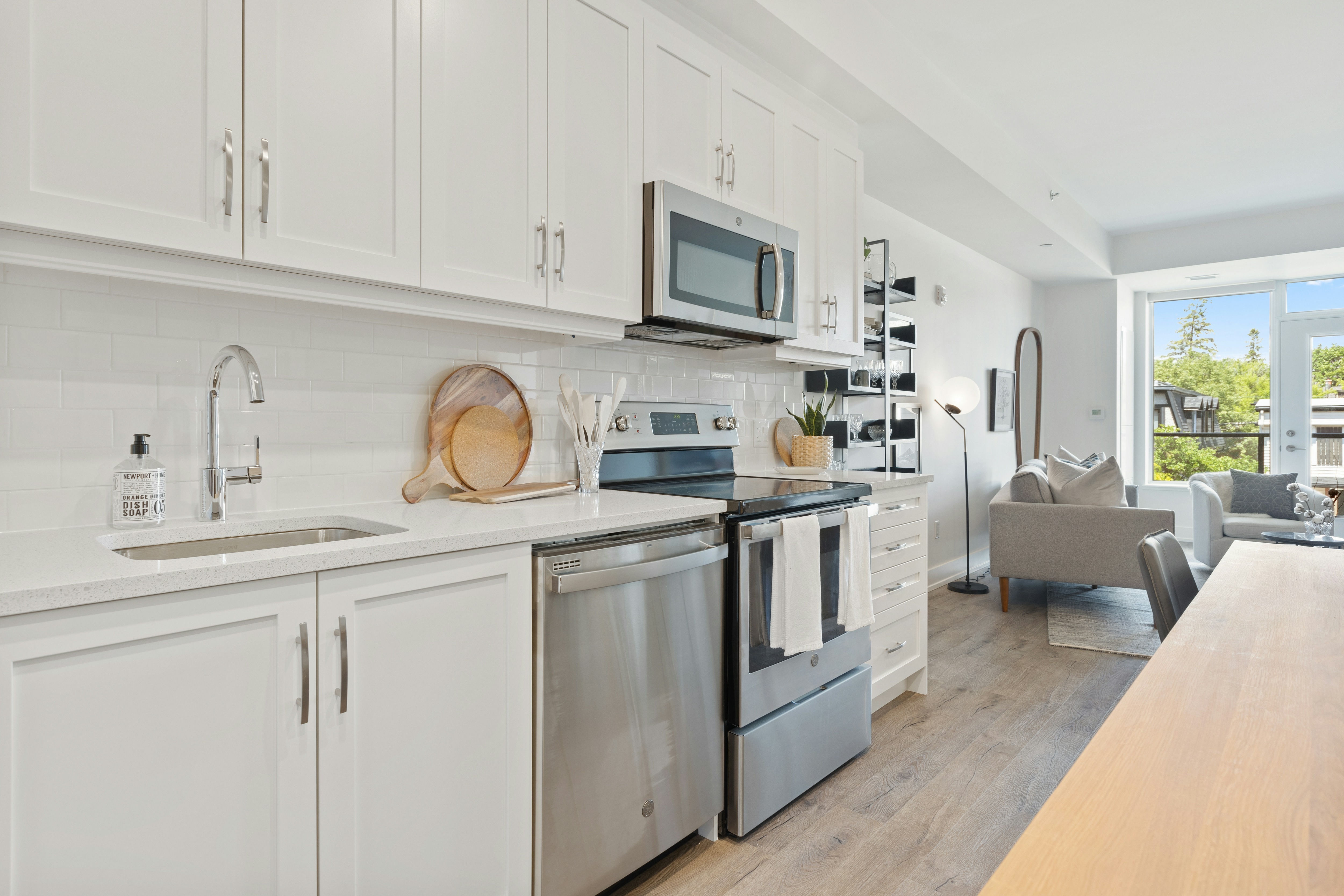 Bright white kitchen opening into a comfortable lounge